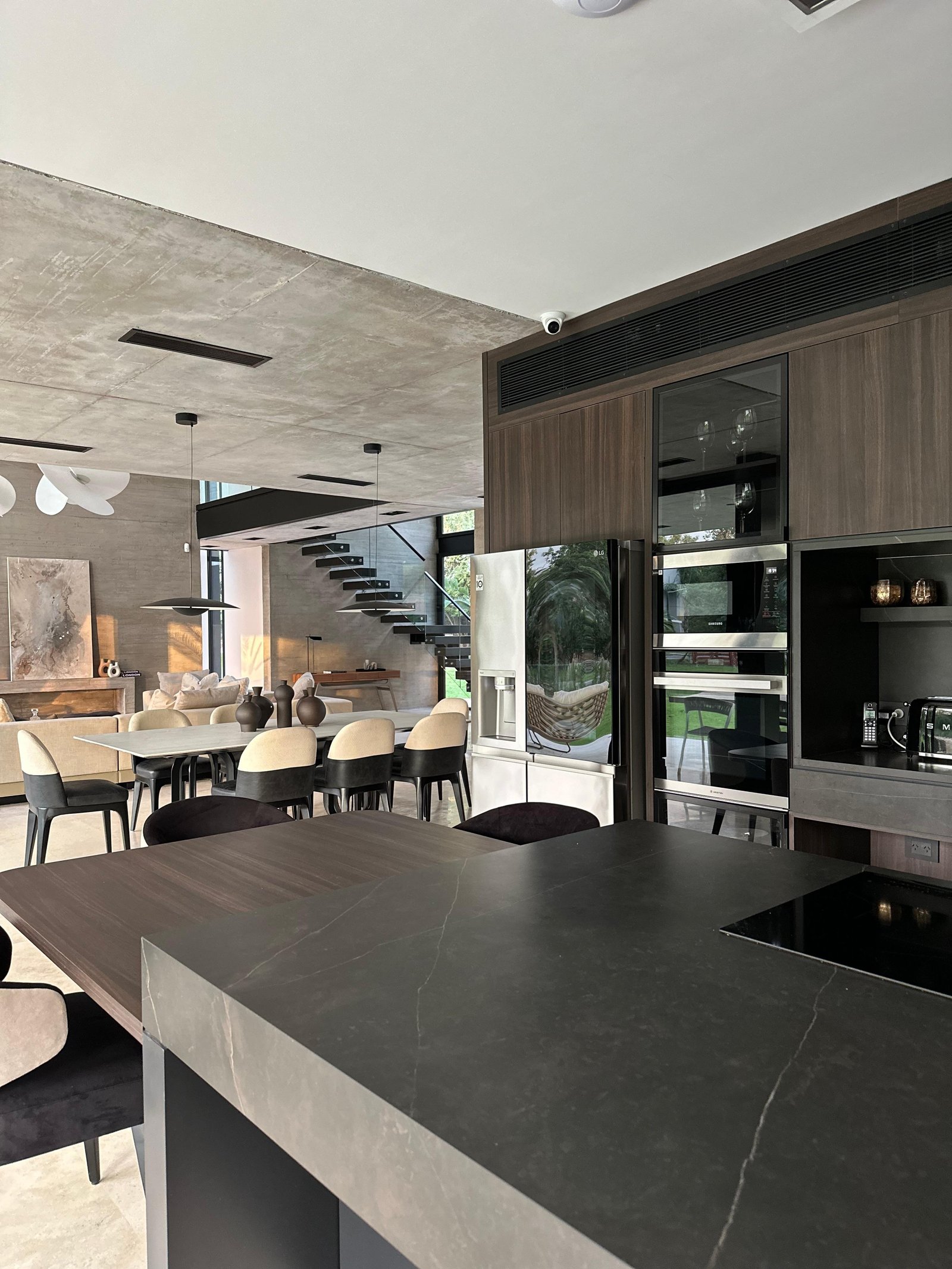 Cocina moderna integrada con isla de piedra oscura y muebles de madera — proyecto Infinito - Estudio Made it , por ABEJA CONCEPT, en Chubut 415
